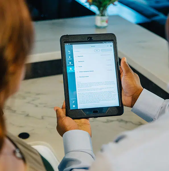 tablet demonstration with device being held by man and reviewed by woman