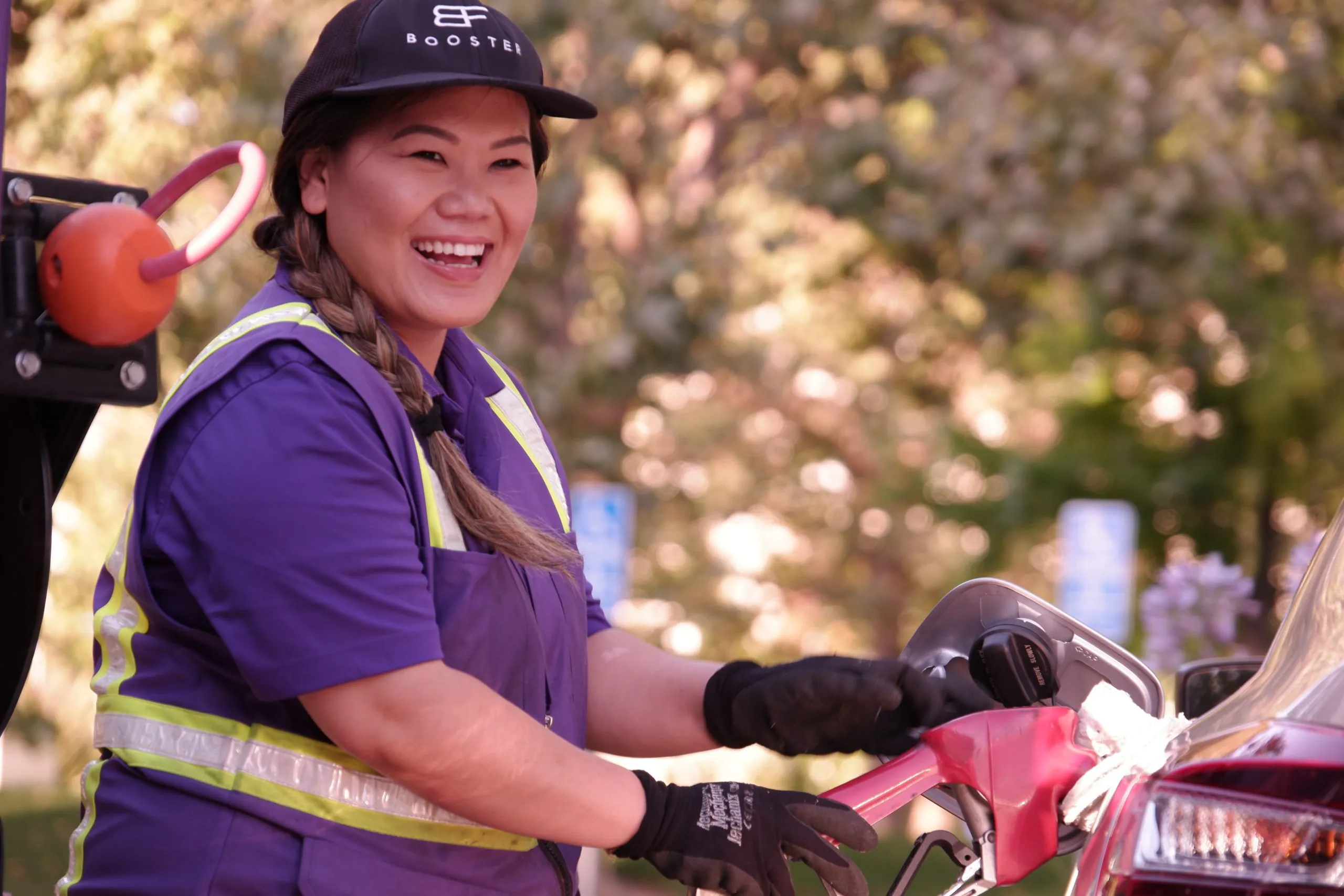 Pacific Asian Booster service professional woman fueling car