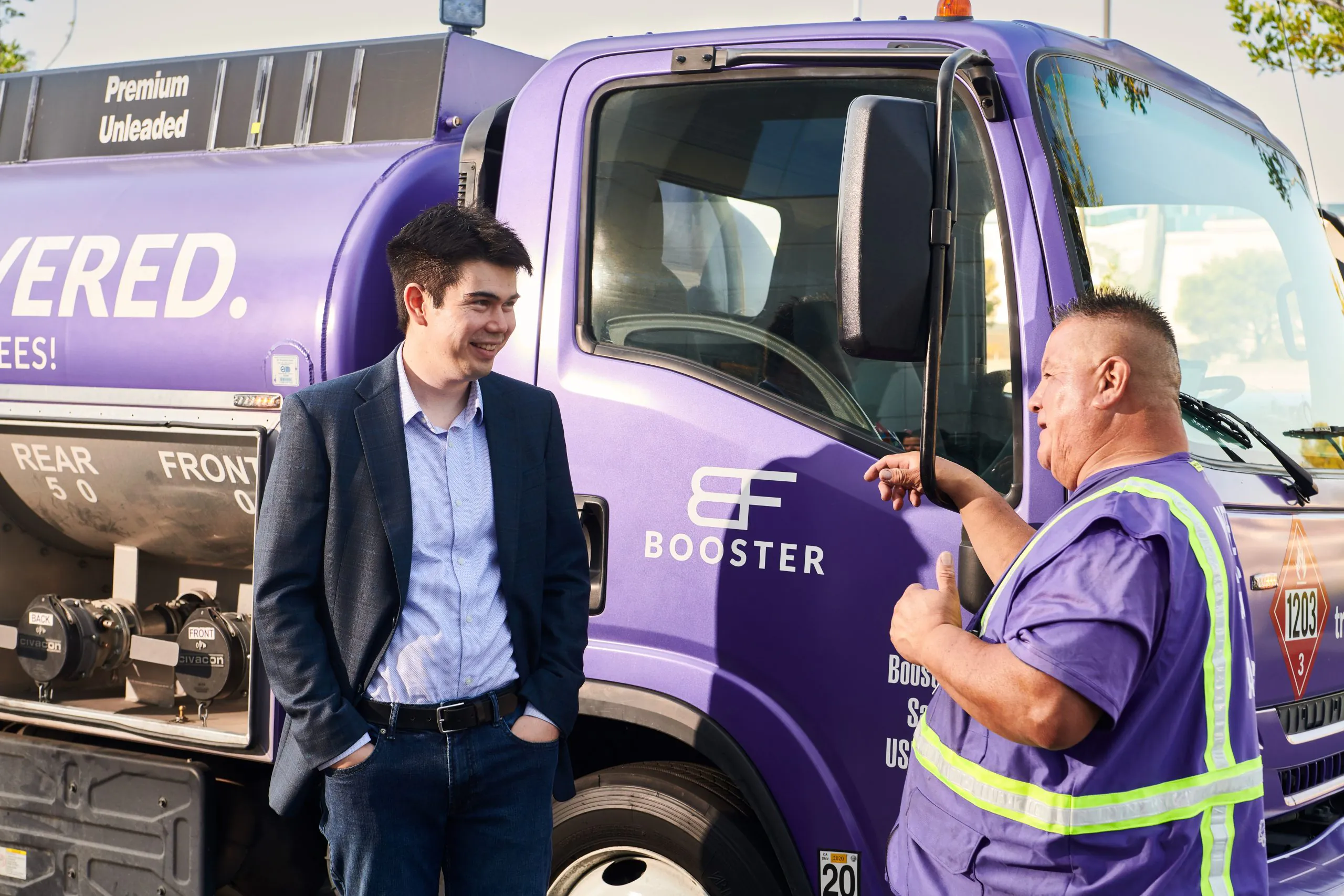 Frank Mycroft and Booster service professional talking outside Smart Tanker