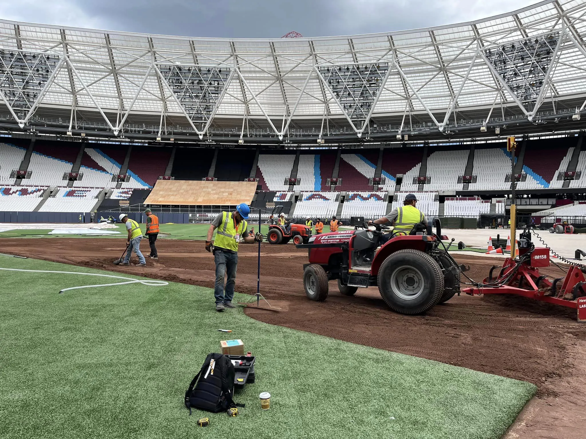 landscapers tending to ball field in a stadium